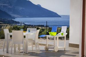 a table and chairs with a view of the ocean at Villa Gloria in Castellammare del Golfo