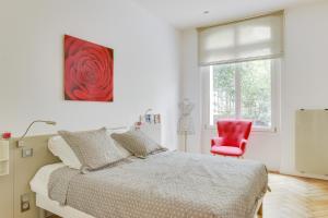 パリにあるMaréchal FOCH Avenue Paris CHAMPS-ELYSÉESのベッドルーム1室(ベッド1台、赤い椅子付)