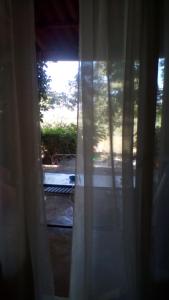 ザキントスにあるAliki's House (Varres)の窓の景色を望む客室で、カーテンが付いています。