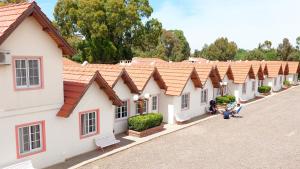 a row of white buildings with red roofs at Cabañas Puerta del Sol in San Blás