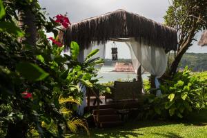 a gazebo with a chair in a garden at Hotel Ponta do Madeiro in Pipa