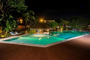 a swimming pool in a resort at night at Hotel Ponta do Madeiro in Pipa