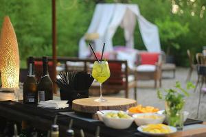 La Striscia Wine Resort في أريتسو: طاولة مع كوب من النبيذ وأوعية من الطعام