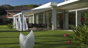 una casa con giardino con ombrellone bianco di Hotel San Marco a Bibione