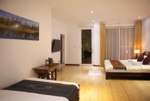 a hotel room with two beds and a television at Angkor Private villa Siem Reap in Siem Reap +24 photos