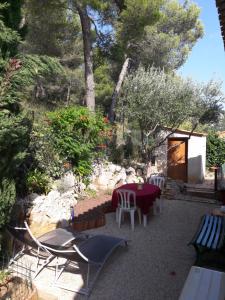 une terrasse avec une table, des chaises et des arbres dans l'établissement MADE IN PROVENCE proche Cassis, à Les Barles