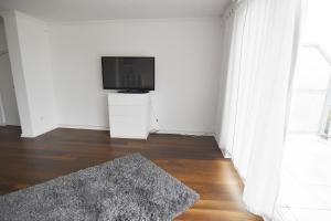 a living room with a flat screen tv and a rug at Dorya am Ring in Cologne