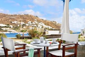 a table and chairs on a patio with a view at Erato Hotel Mykonos in Ornos