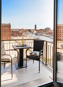 a balcony with a table and chairs and a view at Am Hafen - Ohlerichspeicher in Wismar