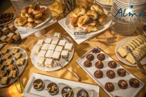 a table full of different types of pastries and desserts at Alma Del Lago Suites & Spa in San Carlos de Bariloche