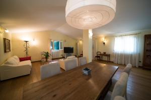 uma sala de estar com uma mesa de madeira e um grande lustre em Florence Country Cottage em Vaglia