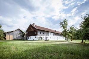 eine große weiße Scheune mit einem Gameradach in der Unterkunft Landhaus Holzen in Pfarrkirchen