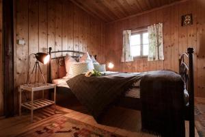 a bedroom with a bed in a wooden room at Landhaus Holzen in Pfarrkirchen