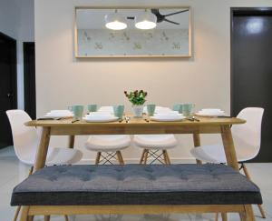 une table en bois avec des chaises blanches et une salle à manger dans l'établissement H2H - Eleven4 Majestic Ipoh, à Ipoh