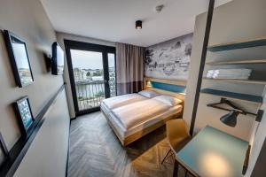 a hotel room with a bed and a balcony at Schulz Hotel Berlin Wall at the East Side Gallery in Berlin