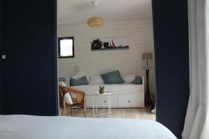 ein Schlafzimmer mit einem Bett, einem Tisch und einem Sofa in der Unterkunft Ker Mouettes in Arradon