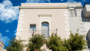 un bâtiment blanc avec des arbres devant dans l'établissement Casa Rosalba, à Grottaglie