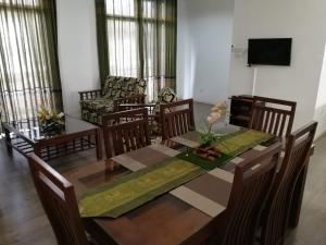 comedor con mesa de madera y sillas en Wishing Well Apartment, en Boralesgamuwa