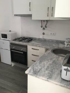 a kitchen with a stove and a counter top at Casinha in Faro