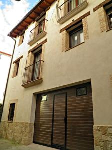 - un grand bâtiment avec une porte de garage devant dans l'établissement Rincón del Valle del Jerte, à Navaconcejo