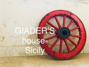 a red wagon wheel sitting next to a wall at Giader’s house - Sicily in Catania