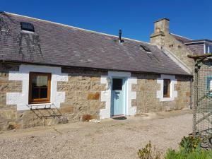 an old stone cottage with a blue door at 6 Seatown, Lossiemouth in Lossiemouth