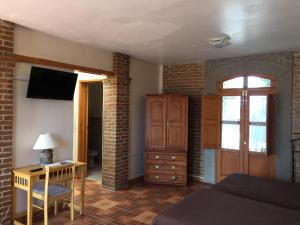 a bedroom with a bed and a desk and a television at Hostal el Dulce Nombre in Huamantla