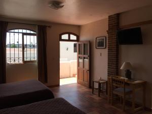 a bedroom with a bed and a desk and a window at Hostal el Dulce Nombre in Huamantla