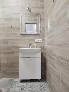 a bathroom with a white sink and a mirror at Apartment - Heart of Odessa in Odesa