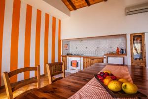 a kitchen with a wooden table with a bowl of fruit at Mansarda sopra il mare in San Marco dʼAlunzio