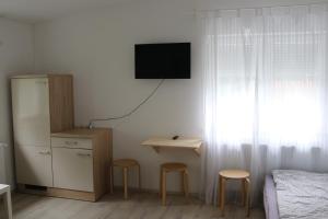 a bedroom with two stools and a television on the wall at Muskat in Hanhofen