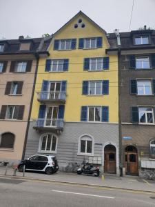 un edificio giallo con un'auto parcheggiata di fronte di ZüriZimmer a Zurigo
