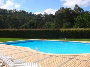 einen Pool mit weißen Stühlen neben in der Unterkunft Quinta da Boavista - Moradia E in Caminha
