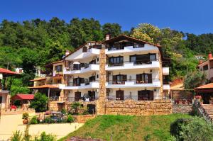 a large white building on top of a hill at Hotel Hera in Skala Potamias