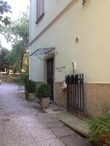 une porte menant à un bâtiment avec un parasol dans l'établissement Alloggio della Villetta, à Palazzolo sullʼOglio
