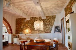 a living room with a table and a stone wall at Casa Magnolia in Terricciola +115 photos