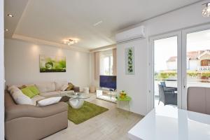 a living room with a couch and a tv at Apartments Vrania in Seget Vranjica