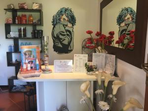 a table with flowers and pictures on the wall at Cala Rosa Club Hotel in Stintino