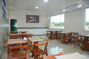 an empty classroom with wooden tables and chairs at Planalto Palace Hotel in Rurópolis