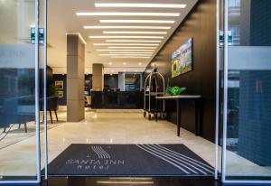 un vestíbulo de oficina con una alfombra negra en el suelo en Santa Inn Hotel, en Balneário Camboriú