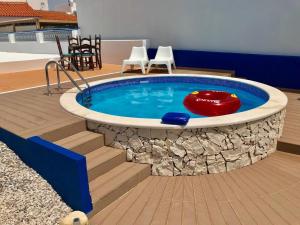 a large plunge pool with chairs and a table at Casa Mestre André in Benagil