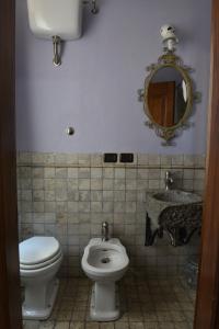 bagno con servizi igienici, lavandino e specchio di Il Palazzetto B&B a Viterbo