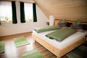 una camera da letto con letto, cuscini e finestre verdi di Ferienhaus Schleinzer a Prebl