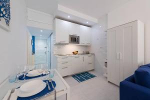 una cucina con armadi bianchi e un divano blu di Casa Ocean Breeze a Las Palmas de Gran Canaria Altre 17 foto