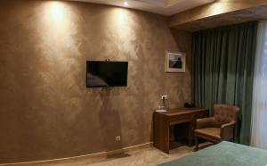 a living room with a couch and a television at Grand Hotel Mimino in Tbilisi City