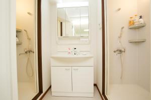 a white bathroom with a sink and a shower at Station Condominium Otsuka in Tokyo +61 photos