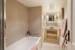 a bathroom with a bath tub and a sink at The Garden Flat in London