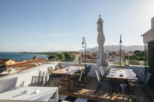 um restaurante com mesas e cadeiras numa varanda em Amaryllis em Lepanto