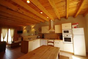 a kitchen with white appliances and a wooden ceiling at Lupin in Formiguères