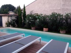 uma piscina com dois bancos em frente a uma casa em Suite dans Une Echoppe em Bègles